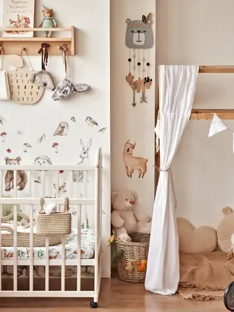 Babyzimmer in Naturtönen mit verschiedenen Waldtieren an der Wand