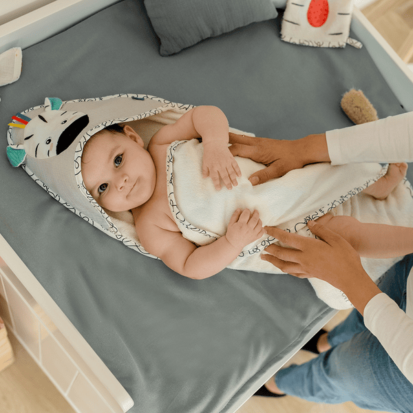 https://img.babymarkt.com/isa/163853/c3/detailpage_desktop_600/-/c8dfe3da65594a20ab0ee1a693f91ac3/fehn-cape-de-bain-enfant-zebre-80x80-cm-a419596